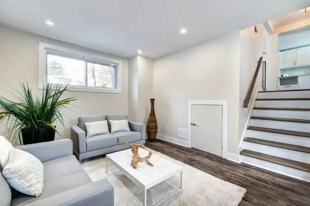 Basement renovation Bronx NY by AlbStar Renovation — finished basement living room hardwood floors recessed lighting staircase