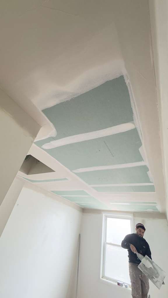 drywall repair cost in the Bronx NY — contractor working on ceiling drywall finishing